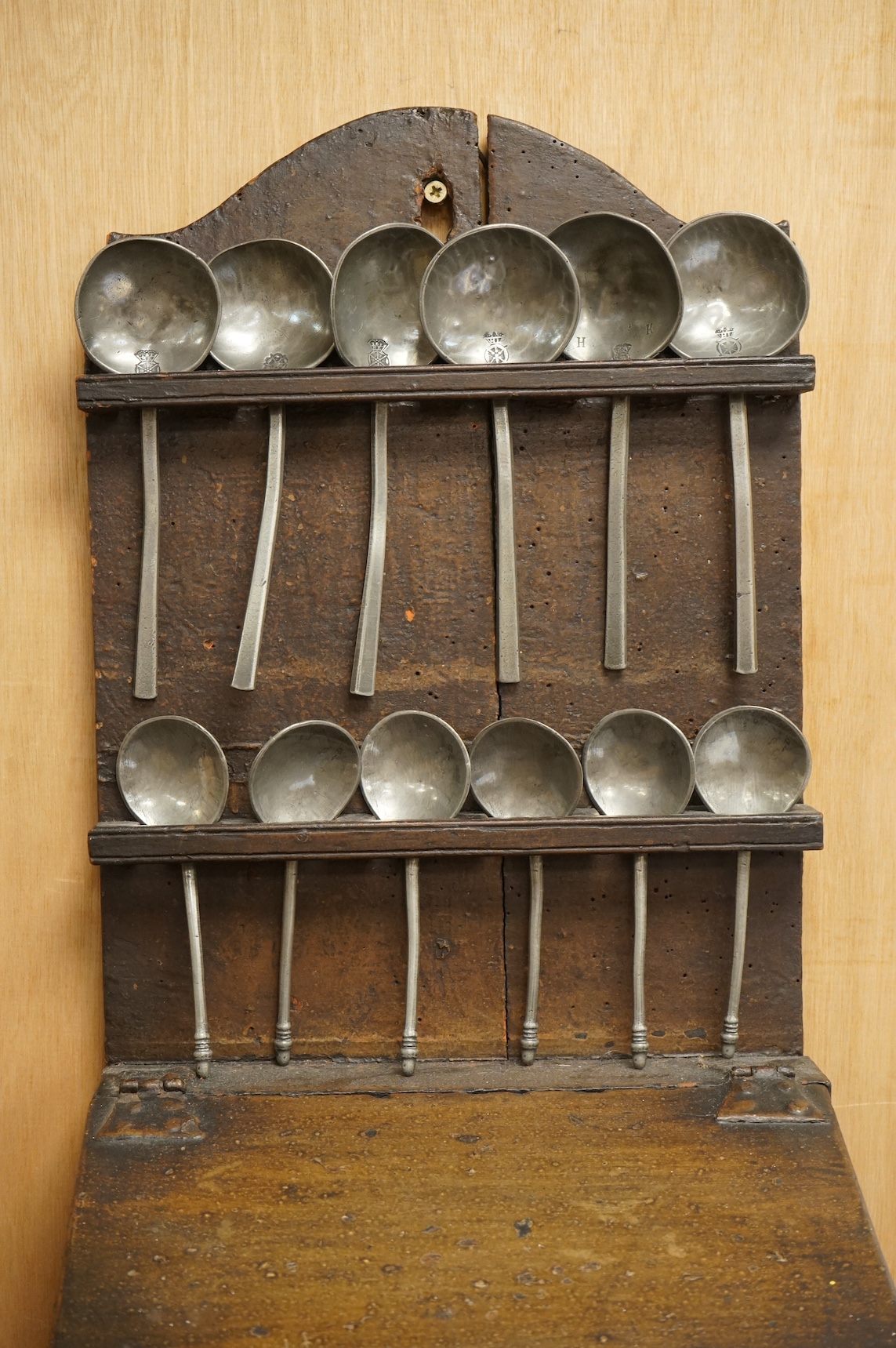 An 18th century oak spoon rack and collection of pewter spoons, 55cm high. Condition - wood cracked